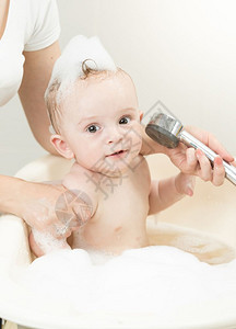 男孩在洗澡时玩浴头图片