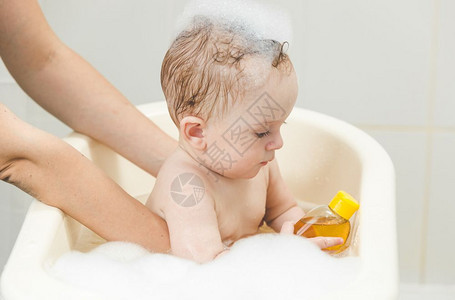 泡澡和玩具的可爱小男孩图片