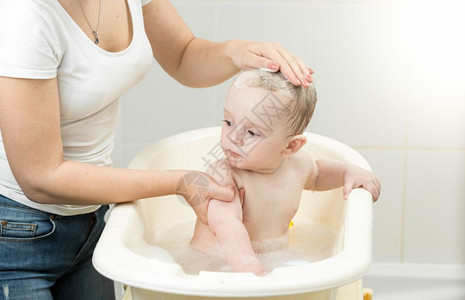 男孩婴儿洗澡和看母亲图片