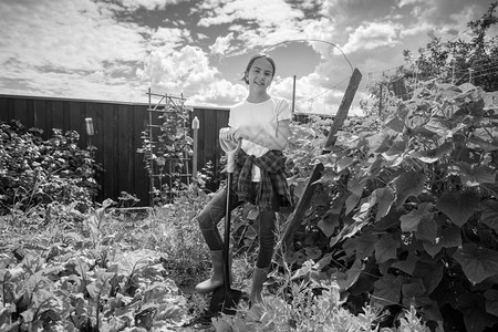 美丽的笑女孩黑白肖像带着铲子在花园里摆着图片