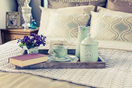 装饰盘托配有书籍茶叶和床上花朵图片
