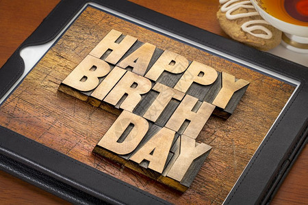 生日快乐贺卡数字平板上带有一杯茶和饼干的纸质木头型文字摘要图片