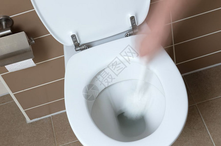洗手间中现代白色厕所碗用洗手刷打扫图片