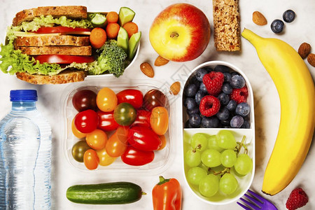 健康午餐盒配有三明治和新鲜蔬菜背景图片