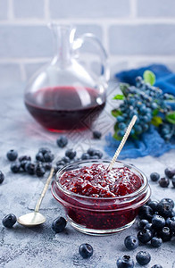 蓝莓果酱以玻璃色和一张桌子图片