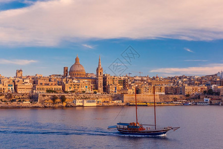 瓦莱塔天线从马耳他日落时的Sliema瓦莱塔天线乘船在美丽的日落时从Sliema天线乘船在马耳他首都瓦莱塔的Carmel山圣母教图片