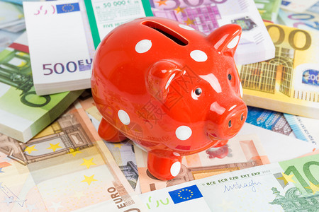 红色粉小猪银行欧元钞票带现金的猪货币箱图片