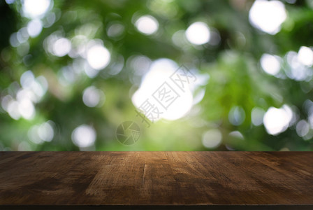 在户外花园灯光的抽象模糊背景面前的黑木桌图像可用于显示或装配产品图片