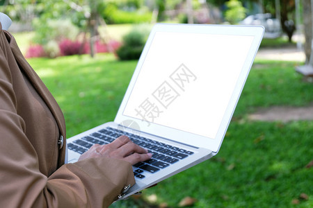 商业妇女使用笔记本电脑在线操作手持键盘的笔记本电脑图片