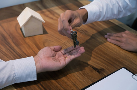 签署合同后向客户提供钥匙的房地产经纪人图片