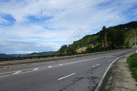 森林公路通往山丘的道路背景