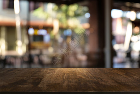 咖啡店的抽象模糊背景面前的空黑木桌可以用于显示或装配您的产品装上以显示产品图片