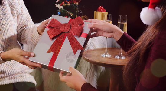 年轻美女送礼物给朋友圣诞节或新年庆祝的概念幸福的高清图片素材