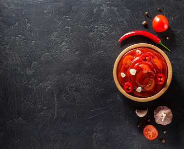 黑背景纹理上的番茄酱碗里加图片