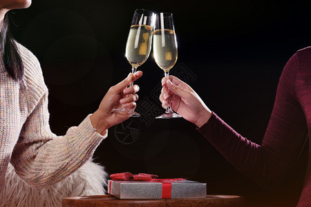 庆祝圣诞节或新年庆祝人们的手与水晶杯满香槟的子在圣诞树附近背景图片