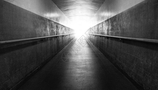 一条长的地下走廊通往表和隧道尽头的光线图片