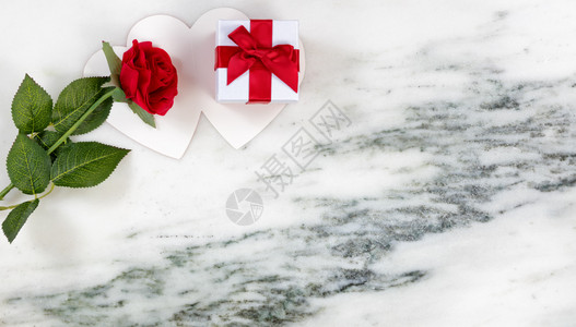 单玫瑰红放在卡片和礼品盒上放在大理石头背景上以平整的面观图片