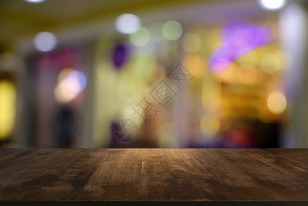 咖啡店的抽象模糊背景面前的空木制桌可用于显示或装配产品图片