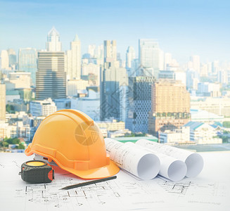 建筑蓝图带有安全头盔和工具适用于建筑高的现代商业区图片