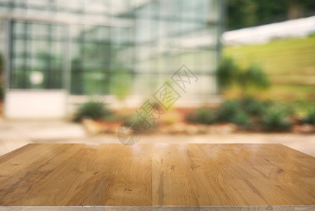 在户外花园灯光的抽象模糊背景前的木制桌子可以用于显示或装配产品图片