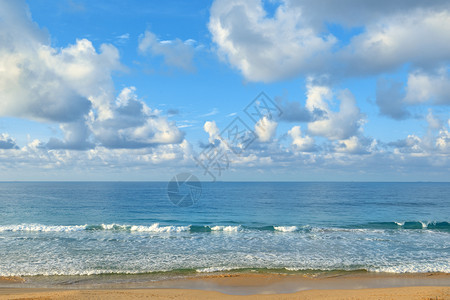 海边晴朗的阳光明媚一天黄沙和蓝海在天空的背面图片