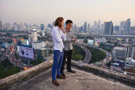 b商业人员集团在城市背景模糊商业技术概念模糊的屋顶上工作图片