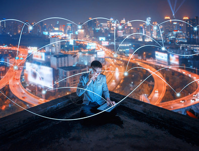 晚上在智能城市使用电话和笔记本脑晚上在智能城市使用社交线路图片