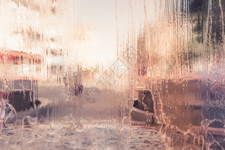 窗口眼镜表面有城市生活背景的雨水滴图片