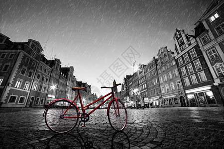 古老的红色自行车在古老的科布勒斯小镇上在雨中黑色和白的颜晚上市场广波兰的沃克拉夫在雨中古老的科布勒斯小镇上旧红色自行车波兰的沃克图片