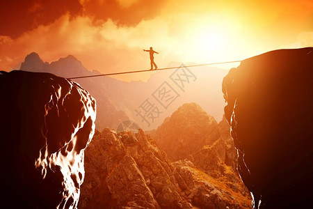 日落时人们在山顶悬崖上行走和平衡商业概念承担风险挑战集中图片