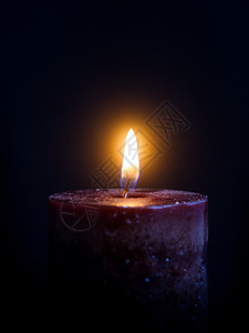 深蜡烛黑暗背景上有燃烧的灯光图片