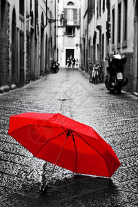 红伞在旧城的科布斯通街上风雨暴天气黑白概念思想理传统回溯风格的颜色红伞在旧城的科布斯通街上风和雨图片