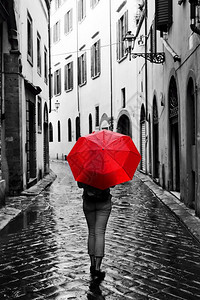 古老城镇的科布斯通街上挂着红色雨伞的女人风雨暴黑白概念思想旧式复古风格的颜色旧城镇街上挂着红色雨伞的女人风和雨图片