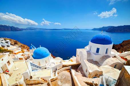 希腊圣托里尼岛的Oia镇希腊传统和著名的白色房子和教堂在爱琴海的卡尔德拉岛上空有蓝色圆丘陵图片