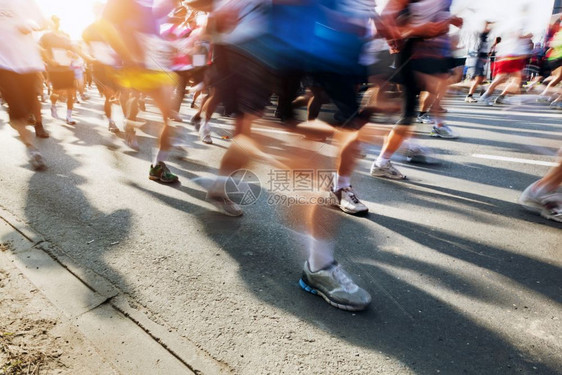 马拉松赛跑者在奔城市阳光照耀在奔跑图片