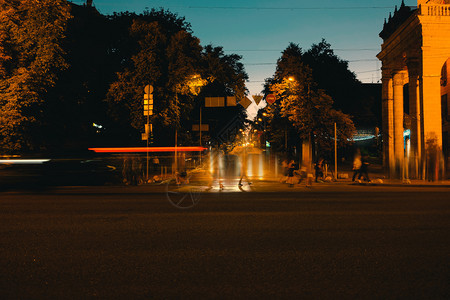 在夜间城市上行驶汽车和人行走模糊图片