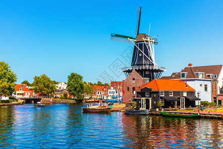 港口物流荷兰Haarlem老城建筑磨厂和运河堤岸的景色夏季象背景