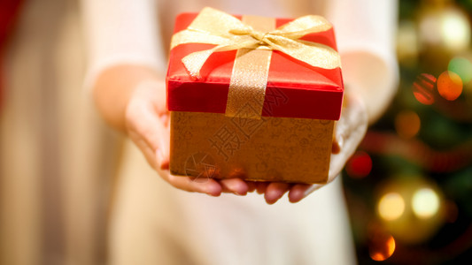 圣诞礼物概念穿着红装的年轻女红装盒的年轻女圣诞礼物概念图片