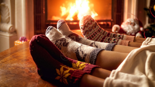 家庭脚在寒冷的夜晚壁炉里穿着羊毛袜子的家庭脚在寒冷夜晚壁炉里穿着羊毛袜子的家庭脚在寒冷夜晚壁炉里穿着羊毛袜子的家庭脚在寒冷紧贴照图片