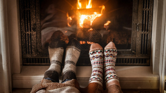 在壁炉旁躺着的羊绒袜子脚贴近照片在壁炉旁躺着的羊绒袜子脚贴近图像图片