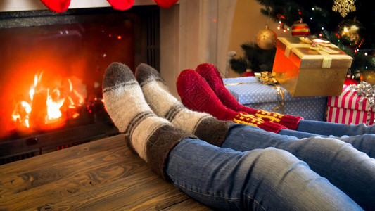 圣诞树旁边的羊绒袜子和壁炉的暖化图片