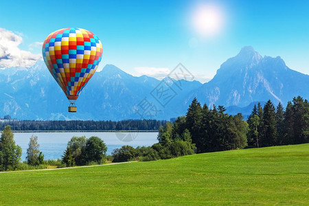 热气球飞越阿尔卑斯山脉地区的草原和森林图片