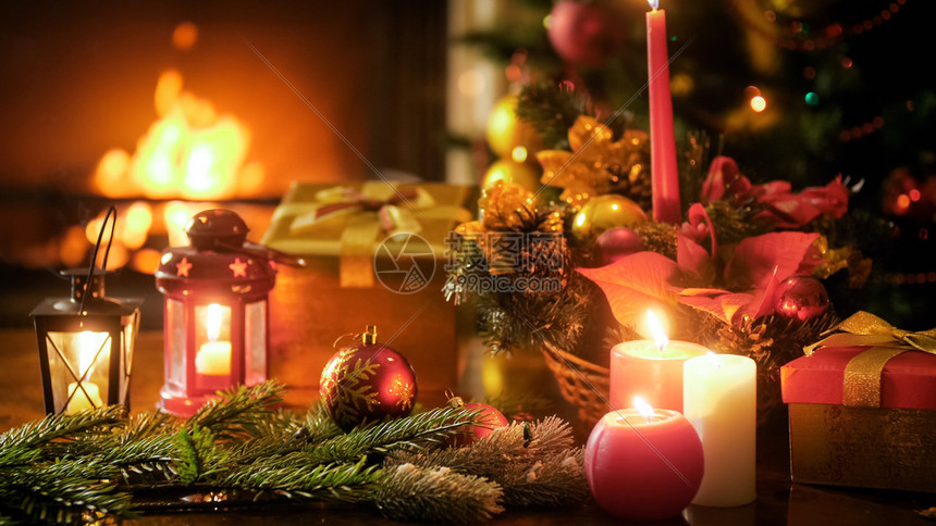 圣诞节背景用蜡烛和灯在木制桌上对着燃烧的壁炉美丽圣诞节背景用蜡烛和灯在木制桌上对着燃烧的壁炉图片