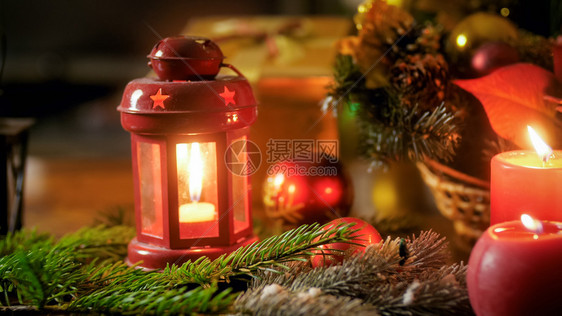 圣诞树枝上灯笼中烧蜡烛的近照图片