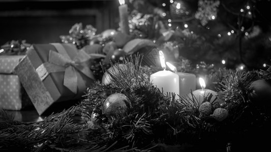 以圣诞树和礼品为对着树和礼品点蜡烛的黑白照片图片