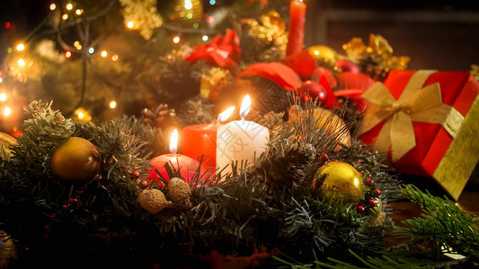 圣诞前夕三根蜡烛在装饰花圈中燃烧图片