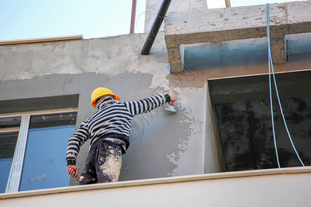 建筑房屋墙壁的石膏混凝土工人图片