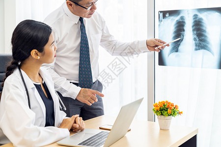 专业医生讨论X光治疗后开进医务室院背景图片