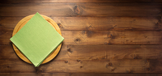 顶视图木制桌面的包切板和餐巾布图片