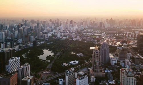 Lumpini公园的空中景象Sathorn曼谷市中心花园亚洲智能城市的金融区和商业中心日落时的Skycraper和高层建筑图片